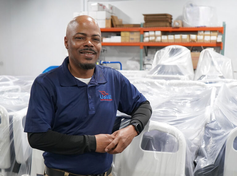 USME Team Lead standing beside a patient-ready hospital bed